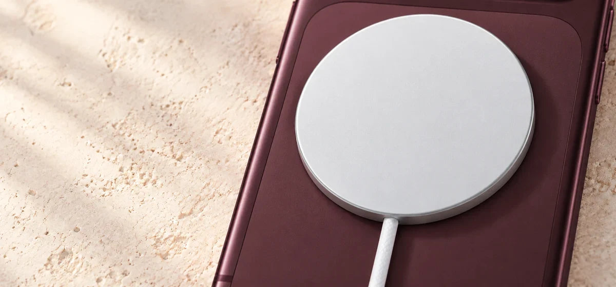 Close-up of a white magnetic charging puck resting flush against a phone back.